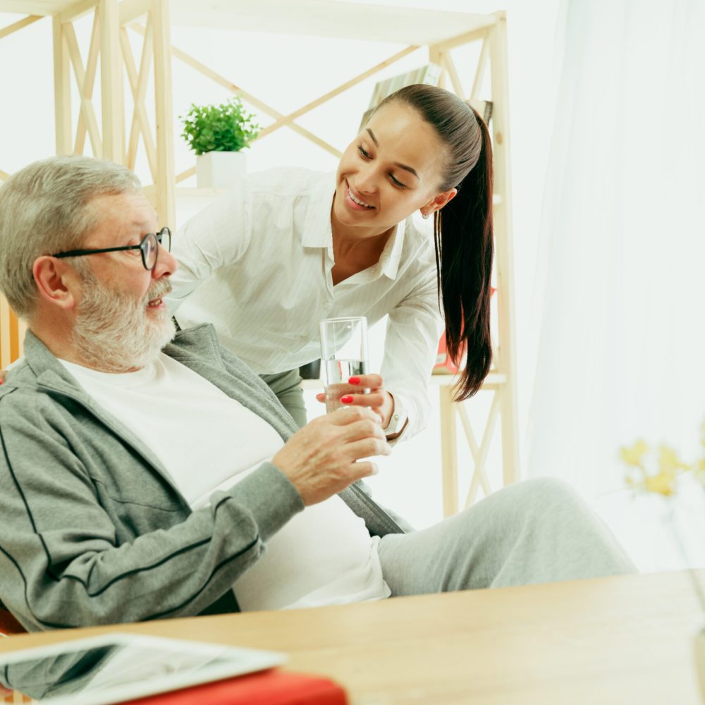 A daughter or granddaughter spends time with the grandfather